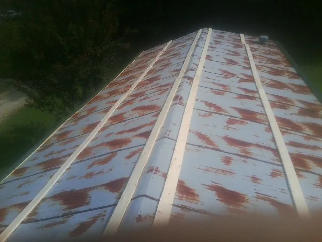 Rusted metal roof panels with new wood purlins before replacement — Storm Damage Roof Repair in Fort Defiance by Roofing Brothers
