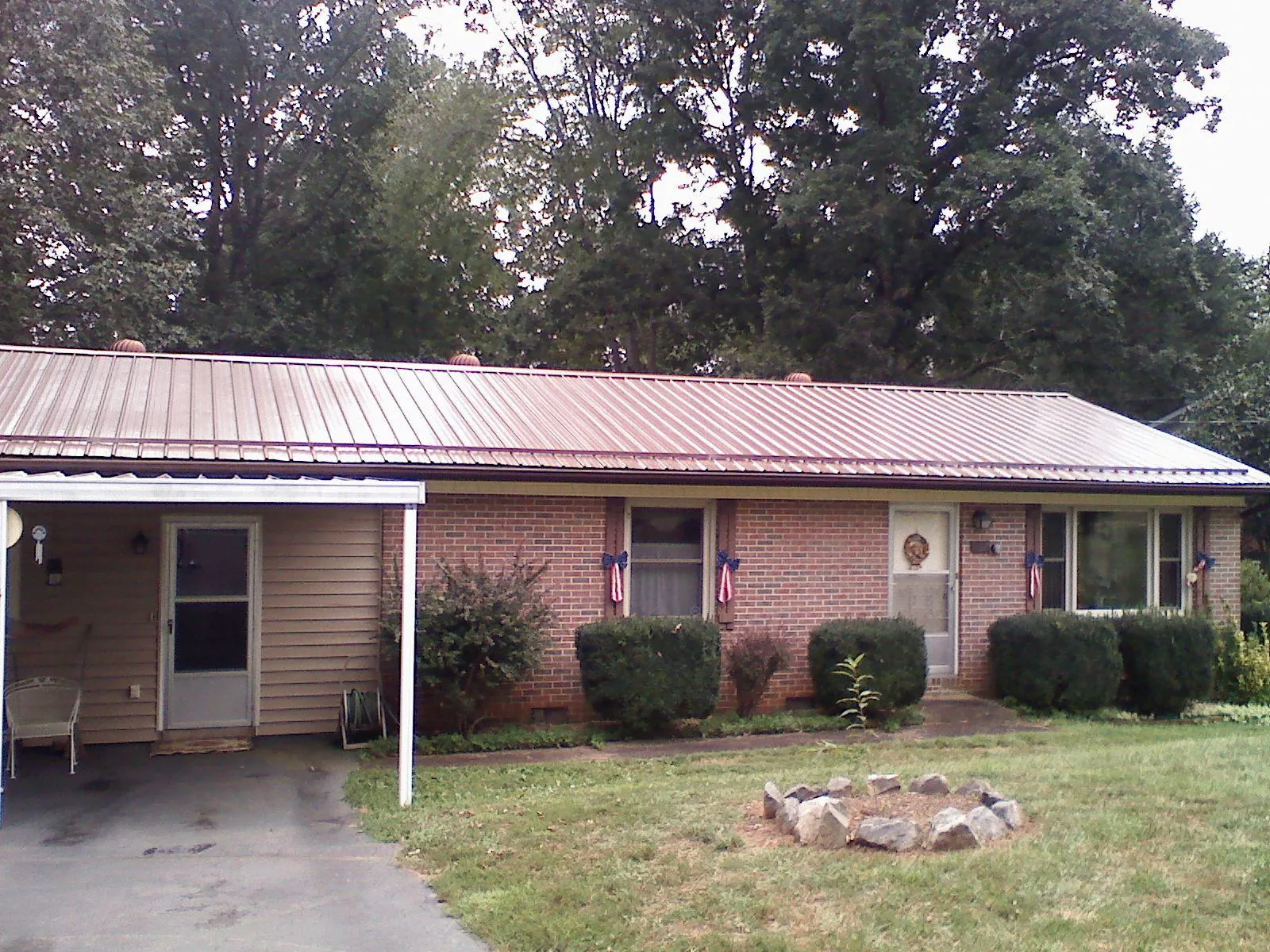 Bronze metal roof and carport on a brick ranch home — Roof Repair work by our crew in Fort Defiance