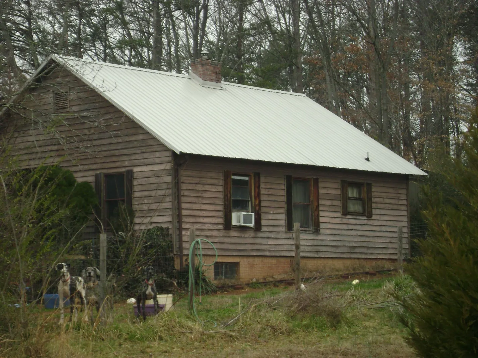 White metal roof on an old wood sided farmhouse, from a Metal Roof Installation job in Fort Defiance